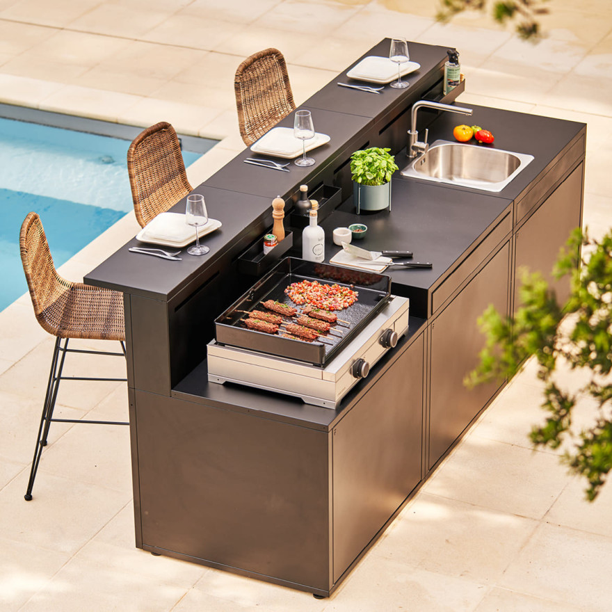 Cuisine extérieure Forge Adour avec plancha, évier et comptoir bar, aménagée au bord d’une piscine sur une terrasse contemporaine.