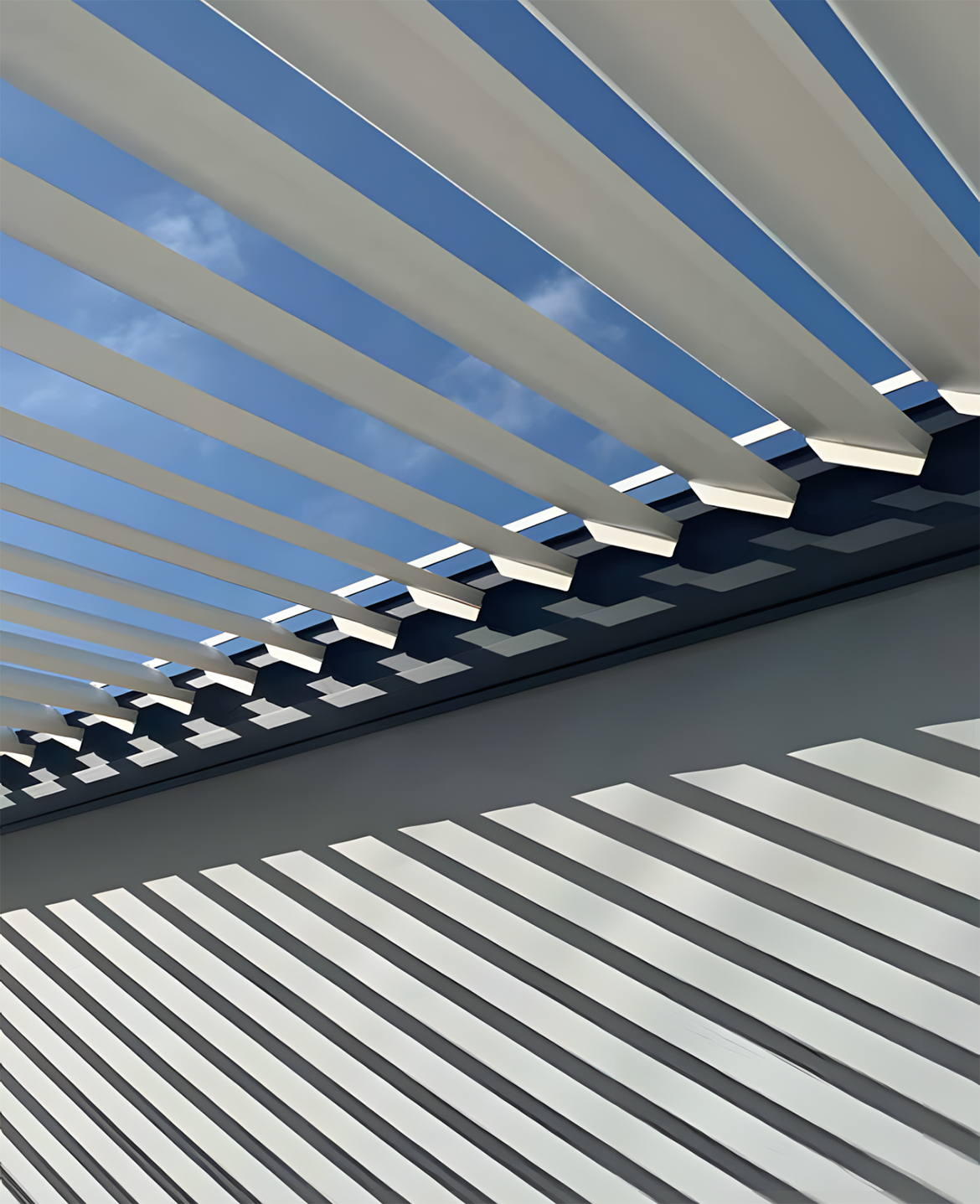 Détail des lames orientables d’une pergola bioclimatique Galaxie laissant passer la lumière naturelle.