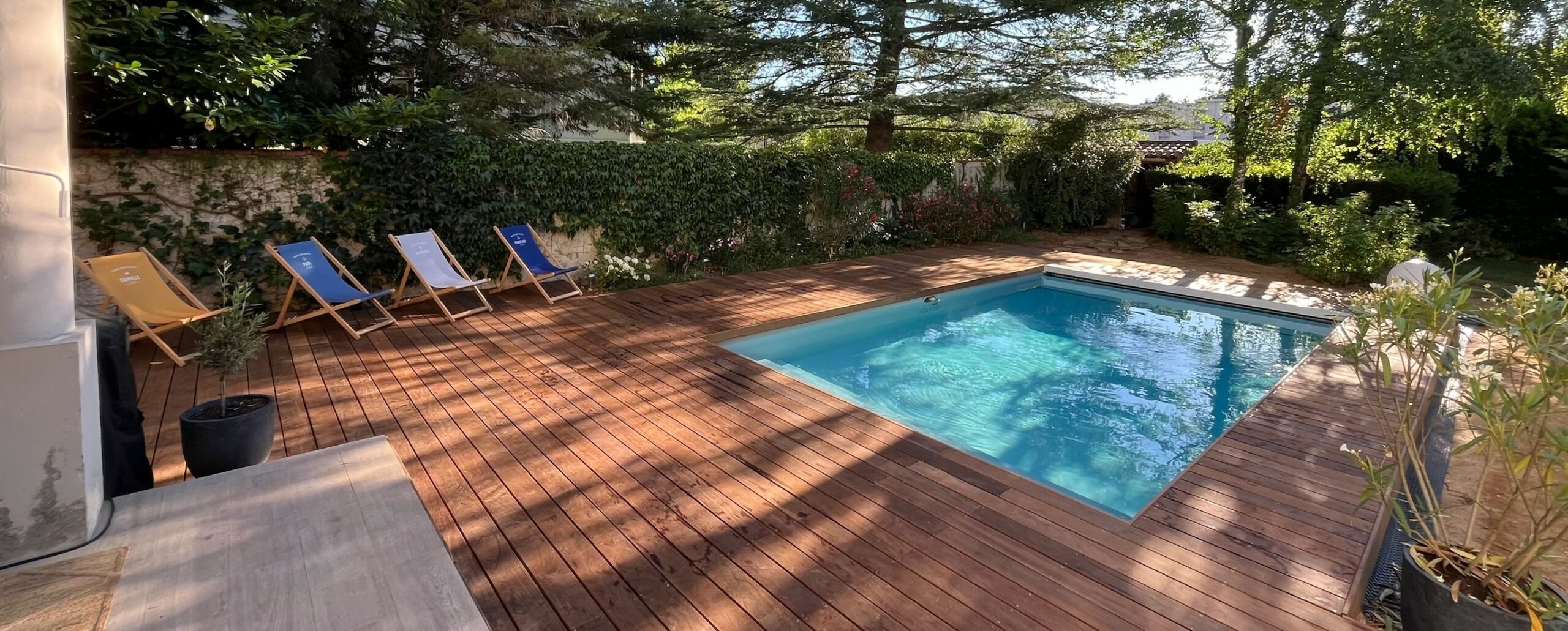 Piscine avec terrasse en bois exotique et aménagement extérieur