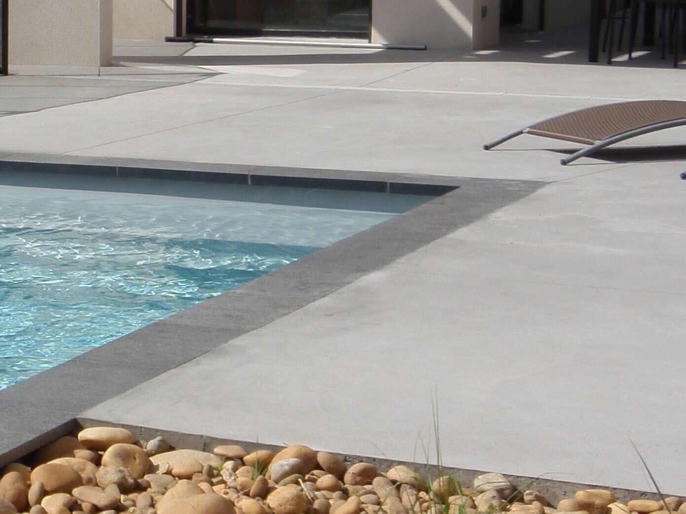 Plage de piscine en béton décoratif avec terrassement et préparation des sols