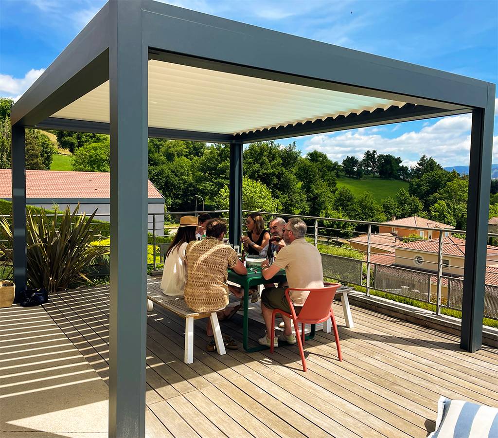 Pergola bioclimatique sur terrasse bois aménagée pour un espace repas extérieur