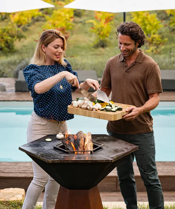 Préparation d’un repas autour d’un brasero plancha en extérieur